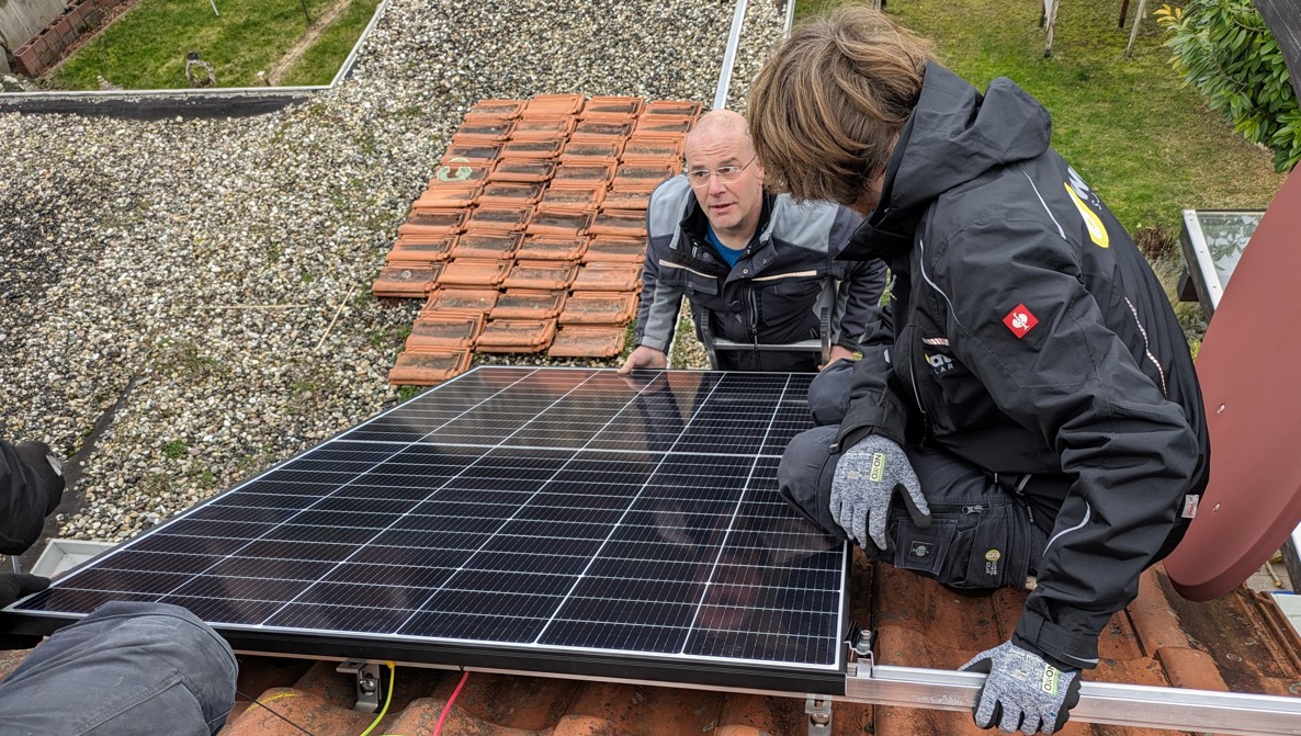 PV-Module werden auf dem Dach montiert, Reihen ausgerichtet und verschraubt